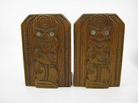 Pair of carved wooden Maori Tiki bookends front view showing carved figures with paua shell eyes.