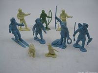 Photo showing all 10 Louis Marx plastic toy figures, variety of colors including blue, green, and cream. Displays figures arranged in rows with some holding weapons and animals in front.