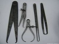 Photo showing 5 vintage machinist calipers on white background, displaying sizes and types including 2 Starrett branded calipers and 3 unmarked ones.