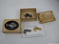 Four Old Oak Bay Marine Group fish pins including two in wooden presentation boxes and two loose pins on a card labeled Captain's Club 2010.