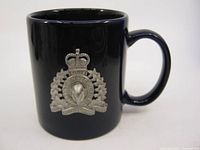 Front side view of the mug showing overall shape and pewter RCMP emblem