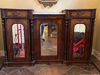 Front view of entire wood credenza showing three mirrored doors, marble top, turned columns and inlaid drawer fronts