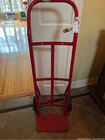 Front view of the red Milwaukee dolly showing the handle, frame, and base plate.