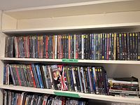 Two full shelves of assorted DVDs incl classical and TV series