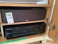 Pioneer DVD player and Zvox speaker in shelving unit with MaxSold lot tag.