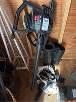 Full view of Toro Super Blower with long nozzle, handle, and visible accessories on ground.