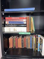 Bookshelves with multiple vintage books including 'Traditional Christmas Cookies', 'The Complete Home Repair Manual', 'Holy Bible', and several older books with worn covers.