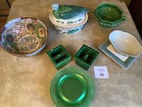 Overview of all ceramic items including bowls, plates, casserole dish, and cups laid out on a surface.