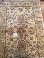 Top section close-up of the rug with symmetrical floral designs and color details visible.