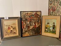 View of all three paintings together, showing the two children at the seashore, the circus children painting, and the flower field children painting.