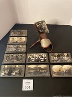 Full lot showing the stereoscope and all 10 photograph cards arranged in front