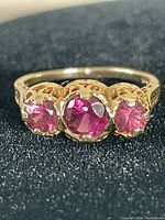 Front view showing three round pink stones in gold setting