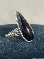 Front and side views of the sterling silver tear drop ring with dark garnet stone set in bezel setting showing band design details.