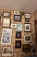 Photo showing a collection of multiple framed arts on a patterned wall including landscapes, birds, butterflies, and architectural drawings.