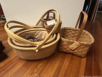 Wide shot showing multiple nesting woven baskets including oval baskets and smaller handled baskets.
