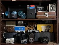 Shelf with assorted cameras, flash bulbs, film pack and box cameras