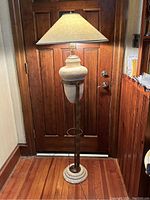 Full view of floor lamp showing ceramic vase-style base, metal stand, and beige fabric lampshade