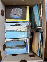 Shoebox containing a mixed lot of postcards showing a variety of landscapes including tunnel views, lakes, canyons and mountain views.