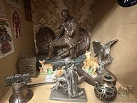 Wide view showing large kneeling George Washington statue, smaller statue, several deer figurines, and brown patterned wallpaper background.