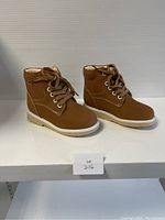 Side angled view of the brown kids shoes showing shape and materials