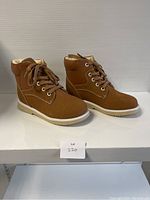 Side view of the brown kids comfort shoes showing shape, side stitching, laces, and sole detail