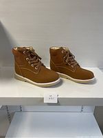 Side view of the brown kids comfort shoes showing the outer side, white sole, and stitching.