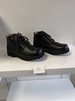 Side view of two black leather ankle boots with laces and zippers, showing details of construction and size.