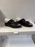 Side view of the new black ladies comfort shoes size 39 wide with adjustable straps on a shelf.