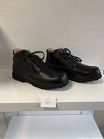 Side view of the pair of black ankle-high comfort shoes showing their profile and treaded soles.