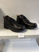 Side view of the pair of men’s black leather comfort shoes with laces and padded ankle.