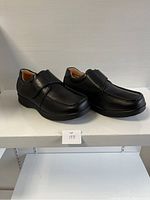 Side angle of black men's comfort shoes showing moc toe, wide strap, and padded collar.