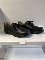 Side view of a pair of men's black leather comfort shoes size 45 with lace-up closure