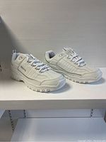Pair of new men's white athletic shoes in size 10, displayed side by side to show overall shape, color, and side details.
