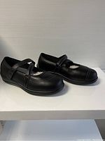 Side view of new black Orthofeet women's shoes, size 8.5 wide, displaying double straps and rounded toe.