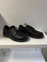 Side view showing black men's lace-up Orthofeet shoes with stitched detailing.