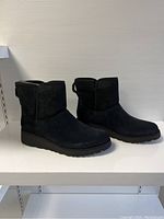 Side and angled view of the pair of black suede UGG boots showing profile and sole design.