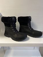 Side profile of pair showing lace-up design, faux fur cuff and overall shape