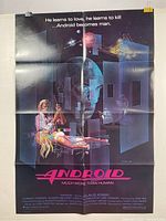 Photo of a vintage Android movie poster measuring 39x26 inches with some visible folding lines and blemishes. Dark background with android head imagery and sci-fi elements.
