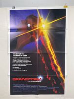 Photo of the Brainstorm movie poster hanging on a wall showing full front view, with visible fold lines and minor blemishes.