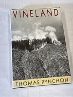 Front cover of 'Vineland' by Thomas Pynchon showing dust jacket with smoke and forest image.