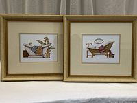 Two framed prints featuring illustrations of vintage bathtubs with bath accessories, displayed side by side.