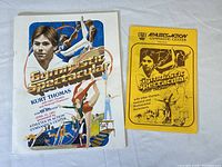 Signed 1981 Kurt Thomas Gymnastics Spectacular souvenir program and yellow flyer together on white background.
