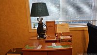 Wide shot of the golf bag lamp with four wooden boxes on a wooden surface by a window