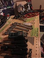 Workbench view with 5 adjustable wrenches in the foreground and screwdrivers grouped at front right