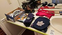 Overview of all items including shoes in box, hats, socks, jewelry box, and red clothing