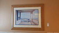Wide view of the larger beach-themed print with a porch, rocking chair and ocean view in a natural wood frame.
