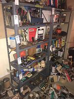 Full view of two gray metal utility shelving units filled with various hardware items.