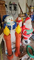 Overview showing two pillar candles, Santa, candy cane, and snowman in garage setting
