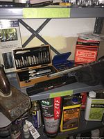 Shelf with wood carving set in wooden case with multiple blades and handles, non-toxic particle mask, wood file, and other tools