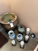 Overview of large and smaller vases alongside candles and electric light